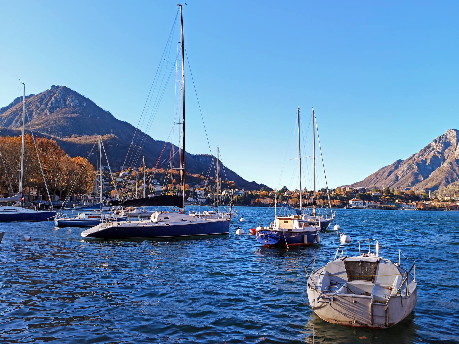 Sailboats moored on the Lecco branch: pleasure boaters, sports enthusiasts and swimmers crowd the lake in summer.